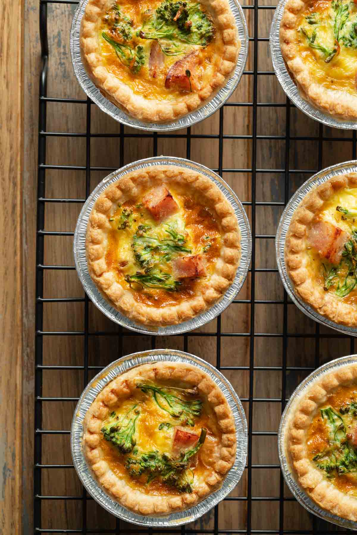 Close up of mini quiches arranged on a wire rack.