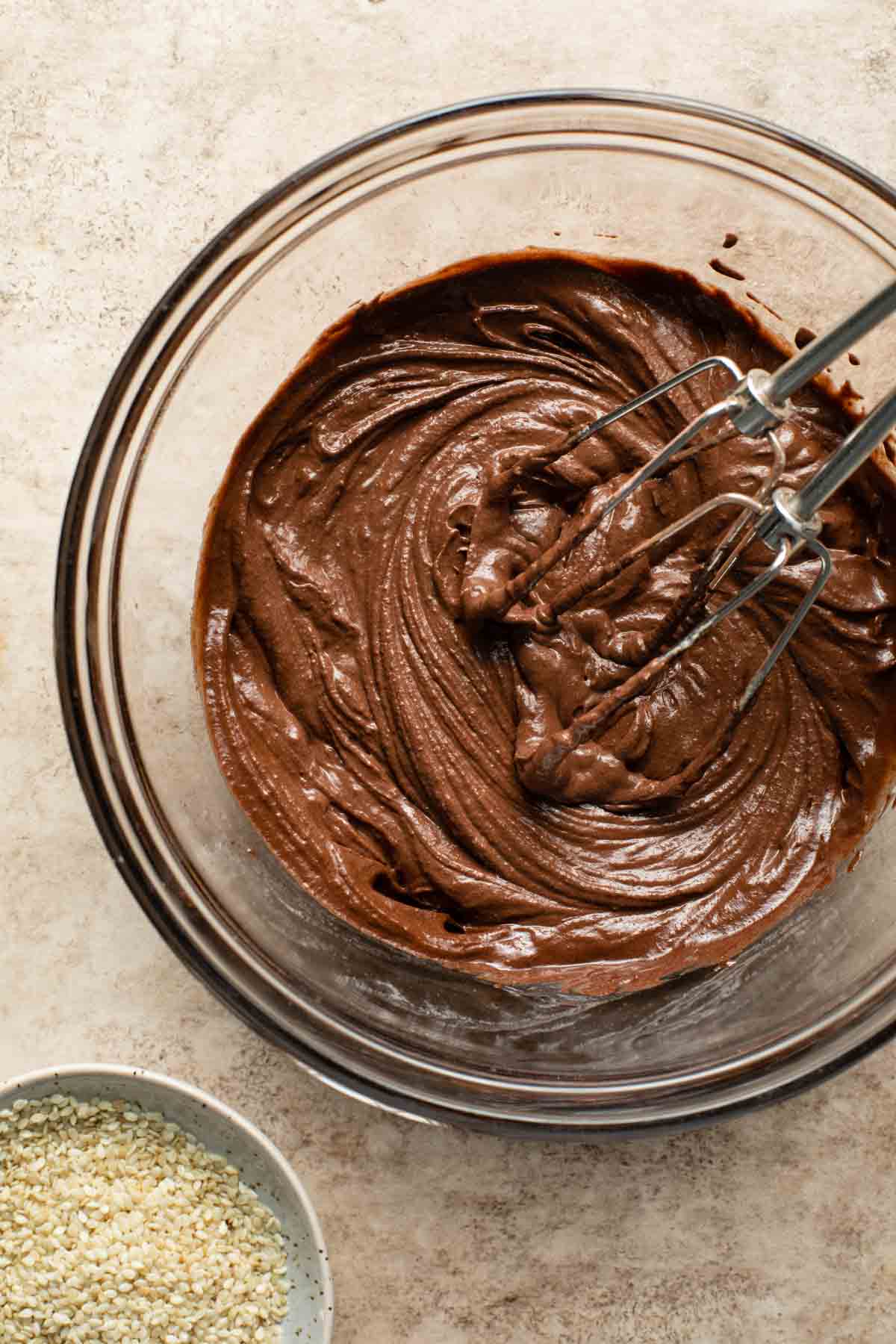Chocolate tahini frosting in a glass bowl.