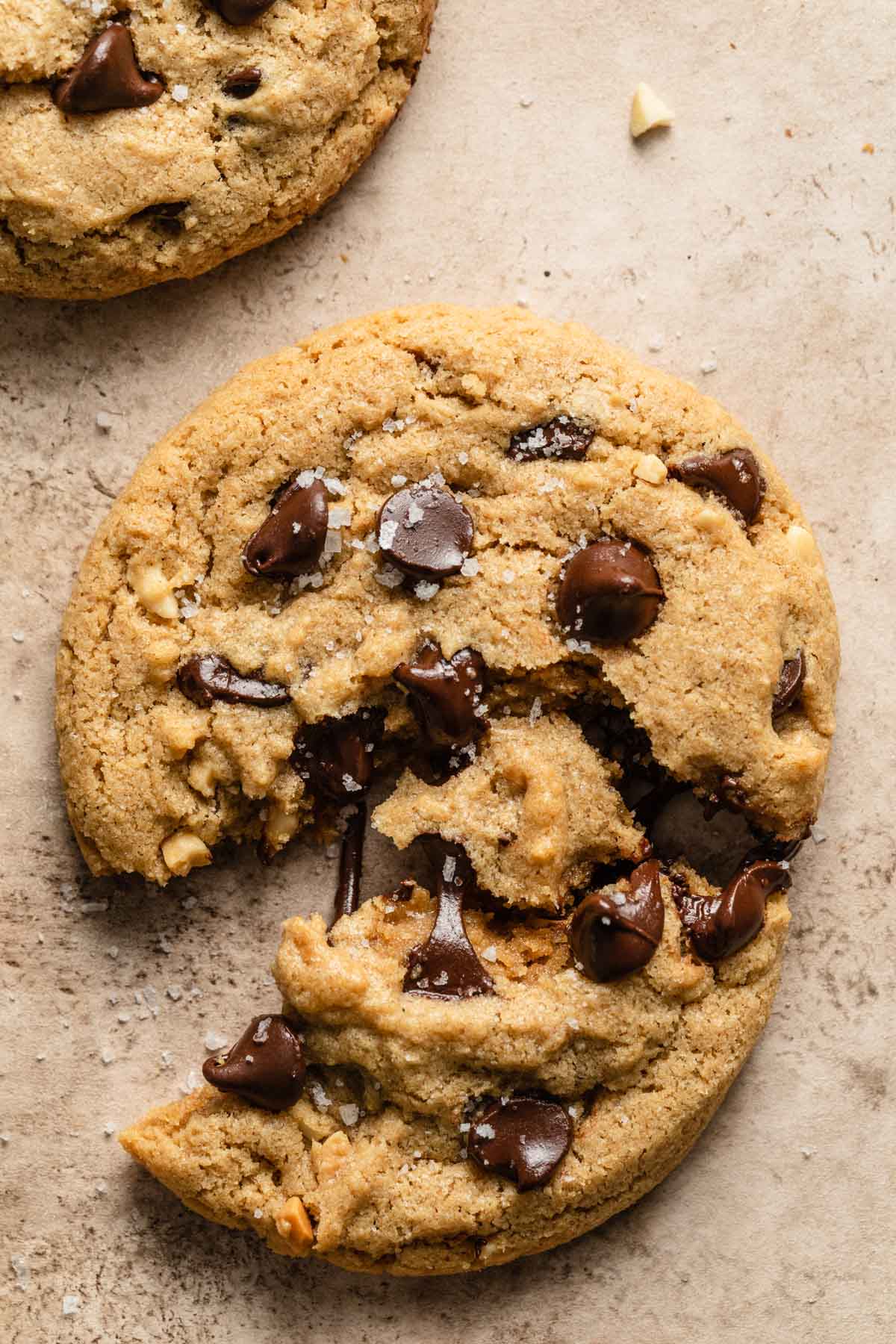 Close up view of a chocolate chip cookie pulled apart and showing the melted chocolate chips.