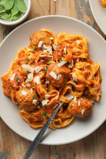 Air fryer turkey meatballs served on a plate with marinara sauce and pasta.