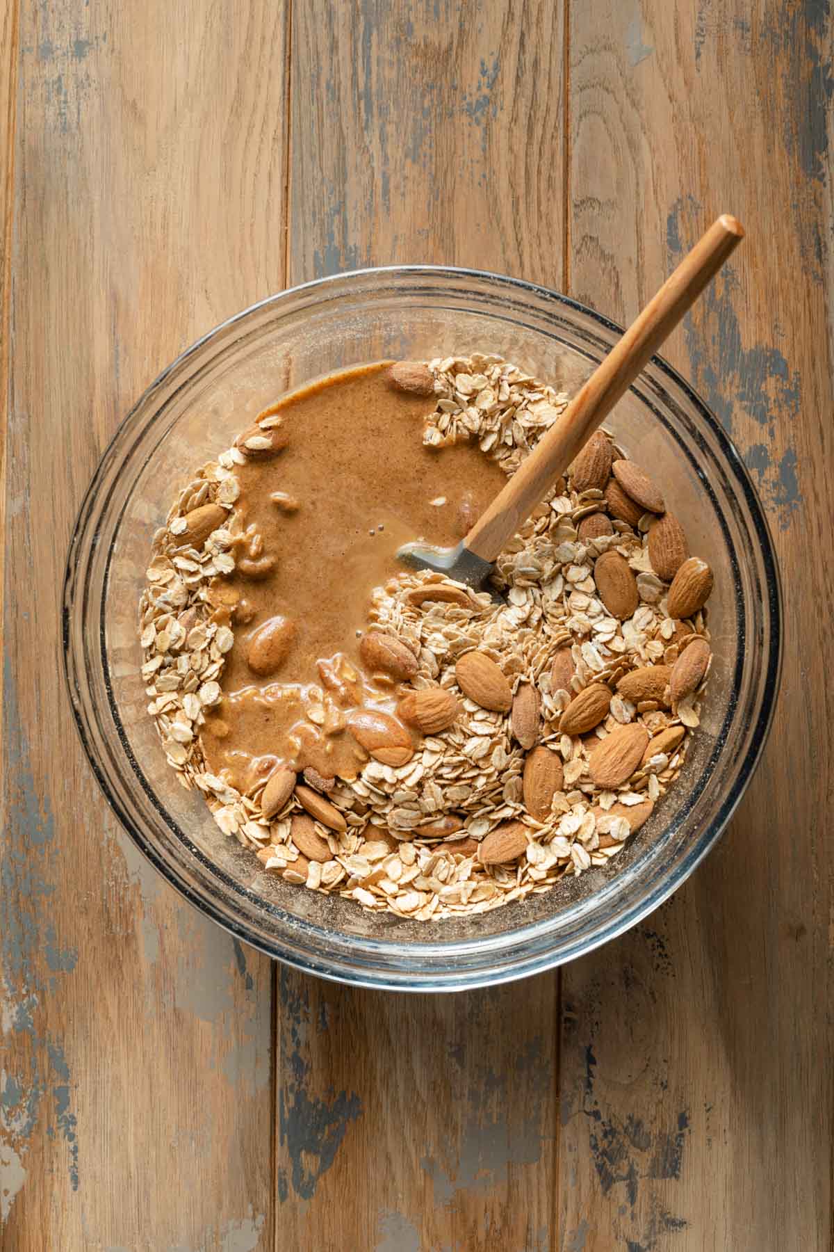Overhead view of granola ingredients added to a glass bowl.