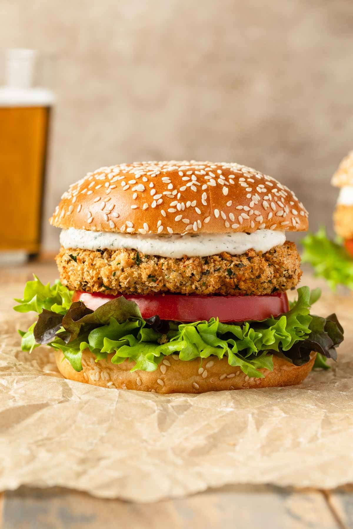 Side view of an air fryer chicken patty arranged on a bun with burger toppings.