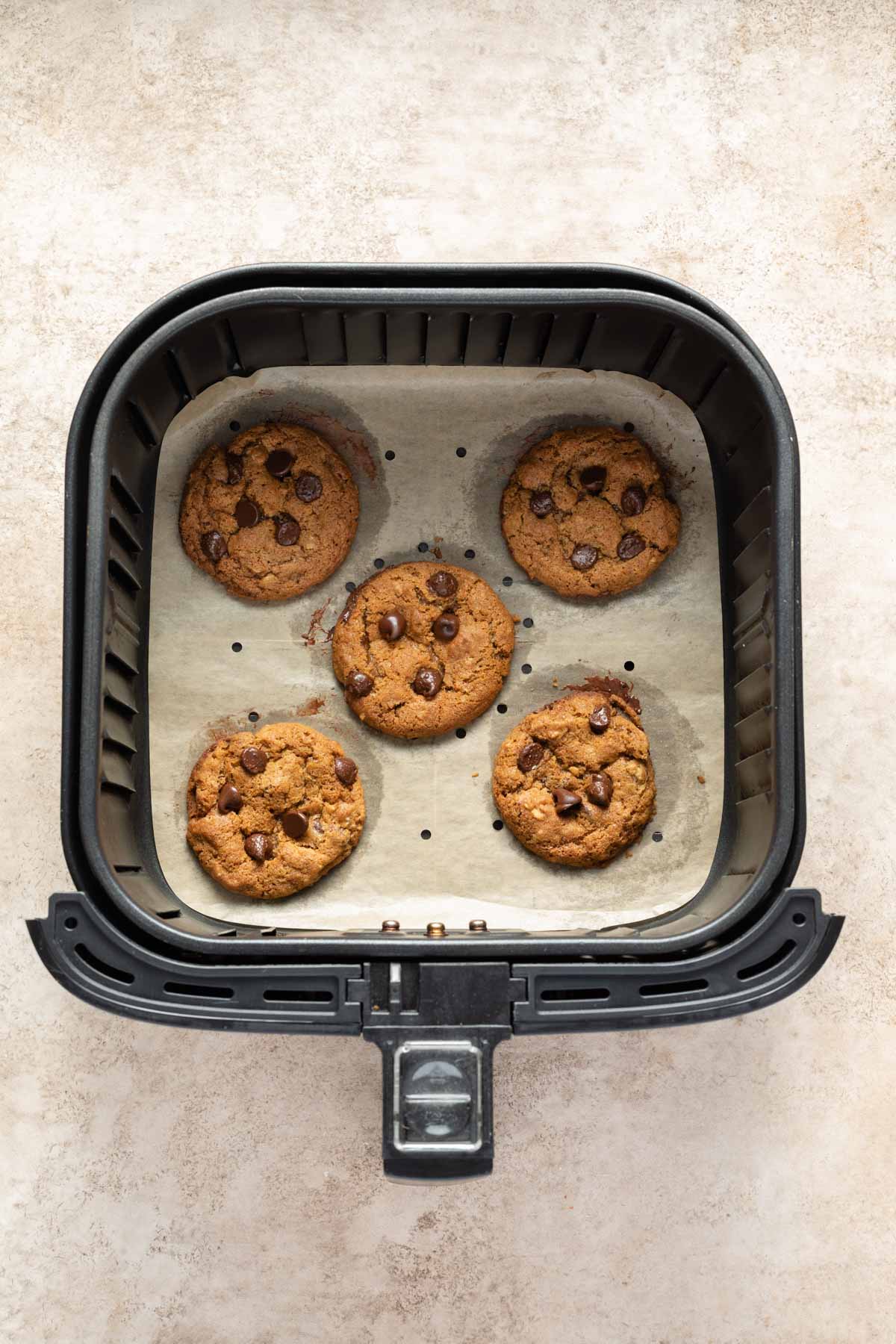 Baked cookies in an air fryer basket.