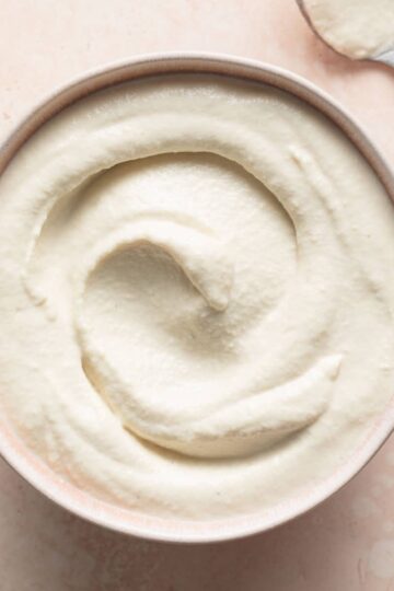 Cashew mayo (vegan mayonnaise) in a pink bowl.