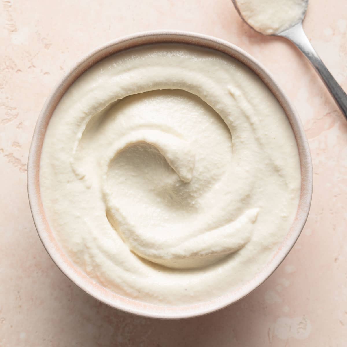 Cashew mayo (vegan mayonnaise) in a pink bowl.