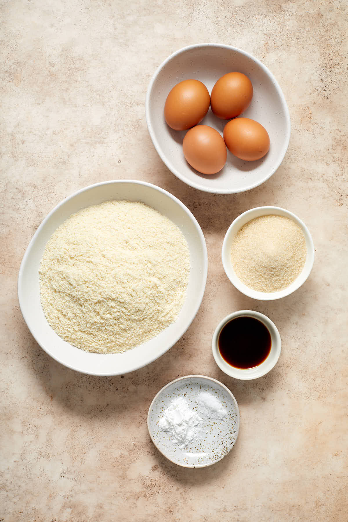 Ingredients to make almond flour cupcakes arranged in individual dishes.