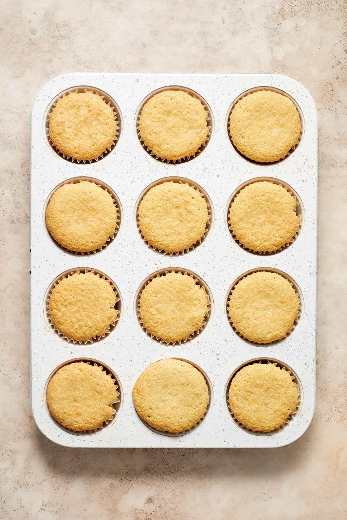Baked cupcakes in a white cupcake pan.