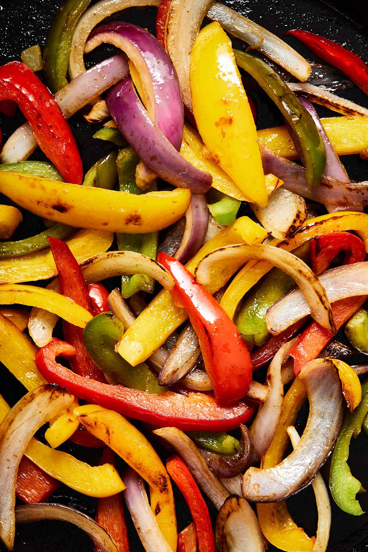 Close up view of sautéed peppers and onions.