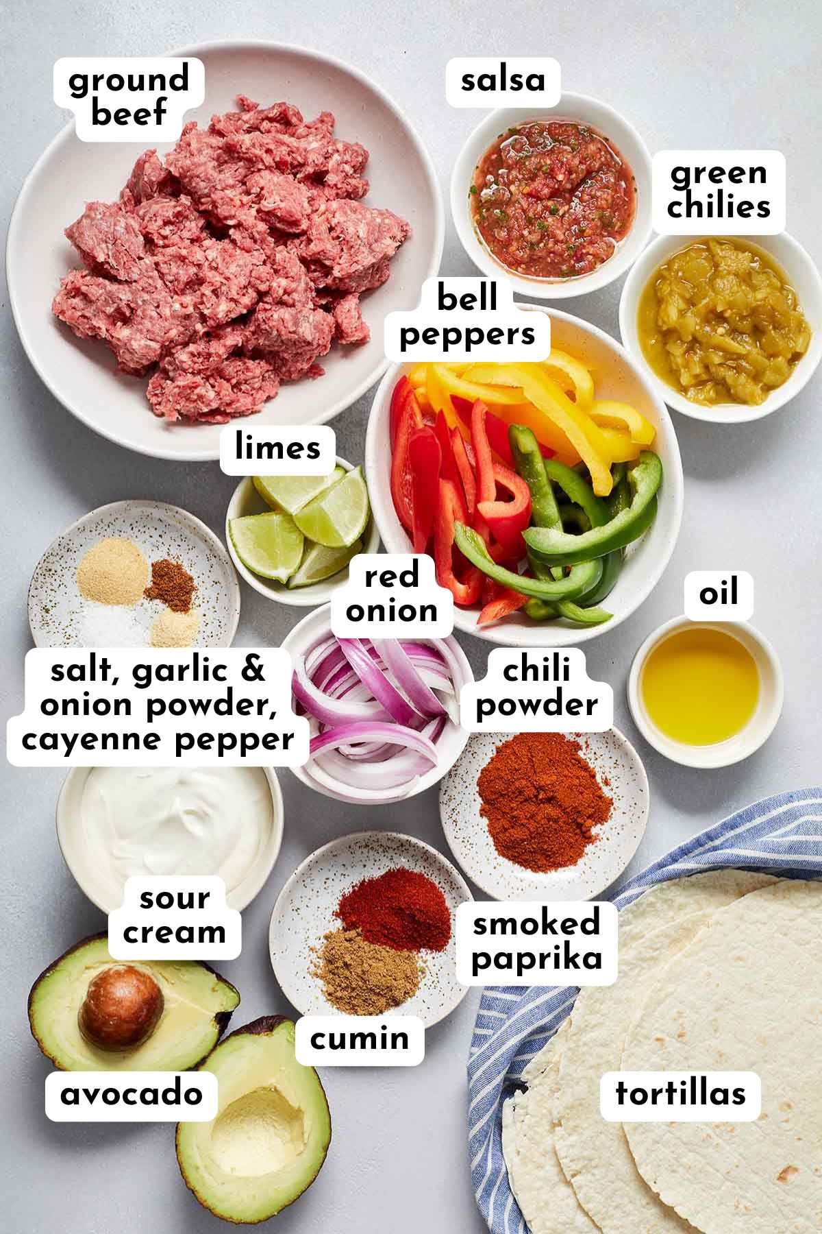 Ingredients for making ground beef fajitas arranged individually and labeled.