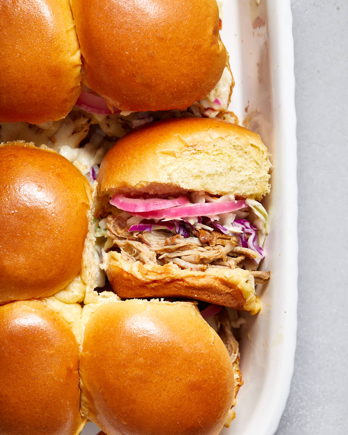 Pulled pork sliders in a white dish.