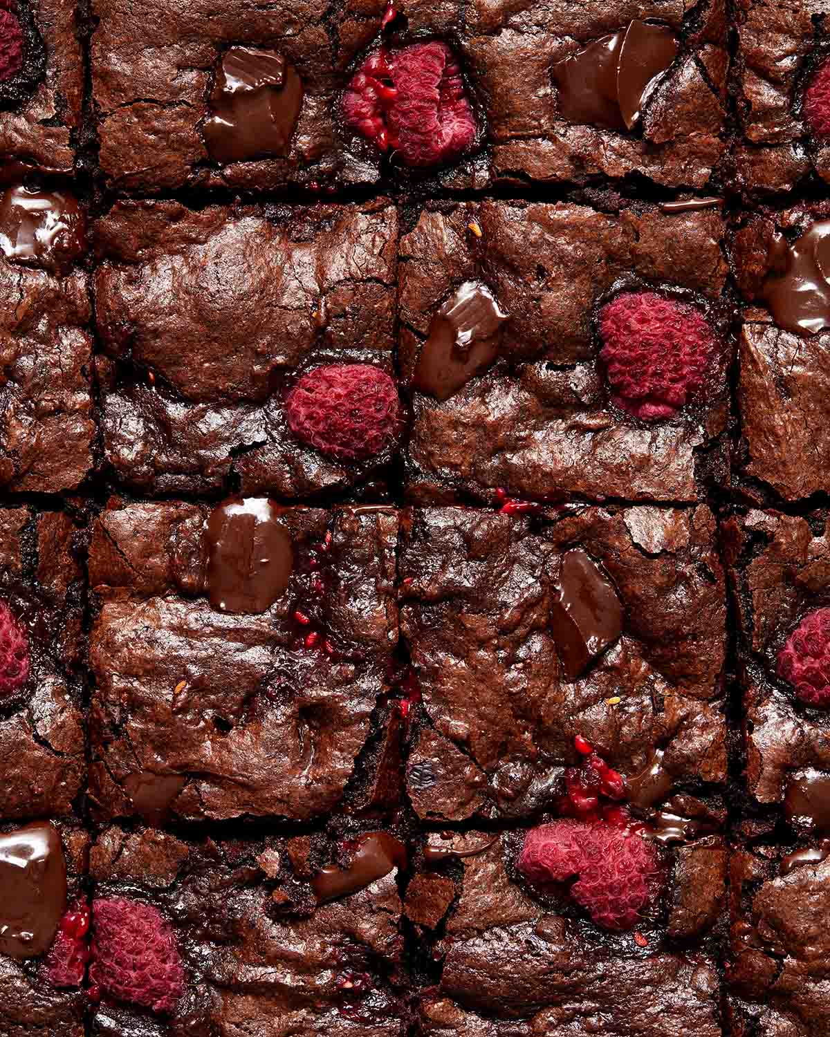 Close up view of raspberry brownies cut into squares.
