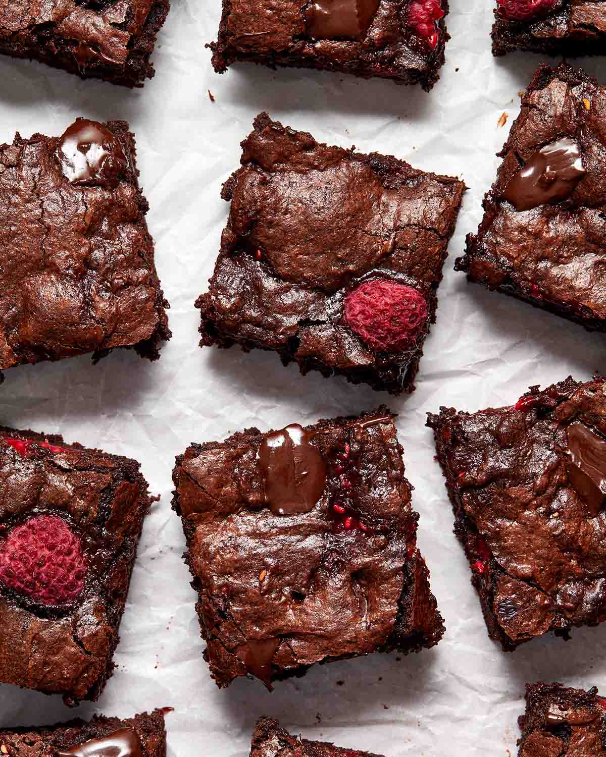 Brownies arranged on crinkled parchment paper.