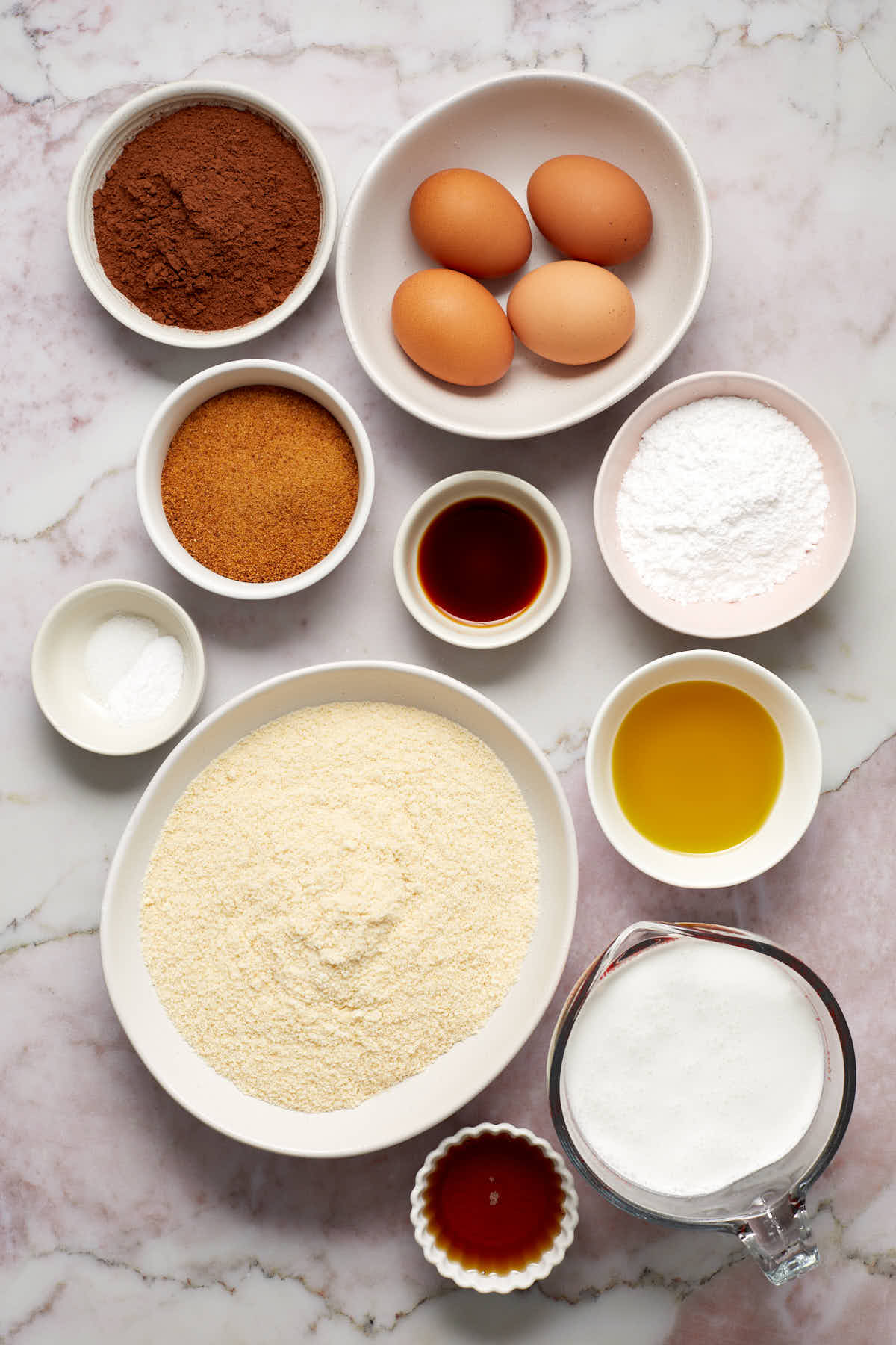 Ingredients to make almond flour chocolate cake arranged in individual bowls.