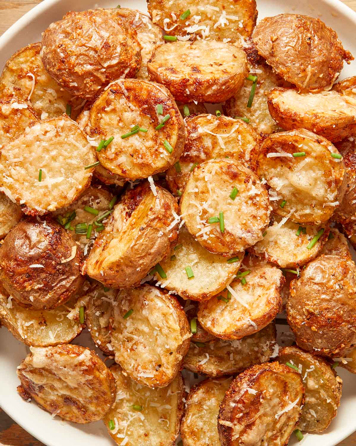 Close up view of air fryer parmesan potatoes on a plate.