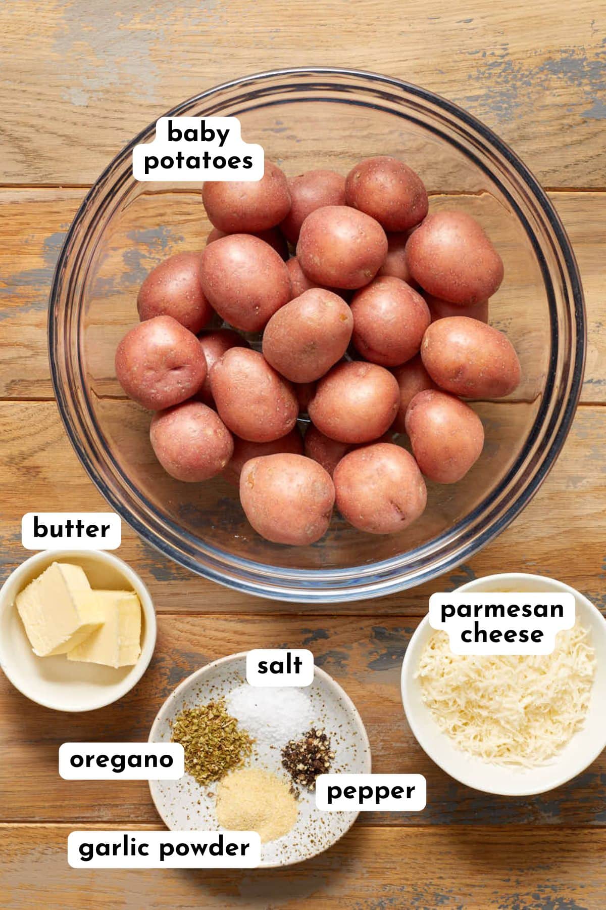Ingredients to make air fryer parmesan potatoes arranged in individual dishes and labeled.