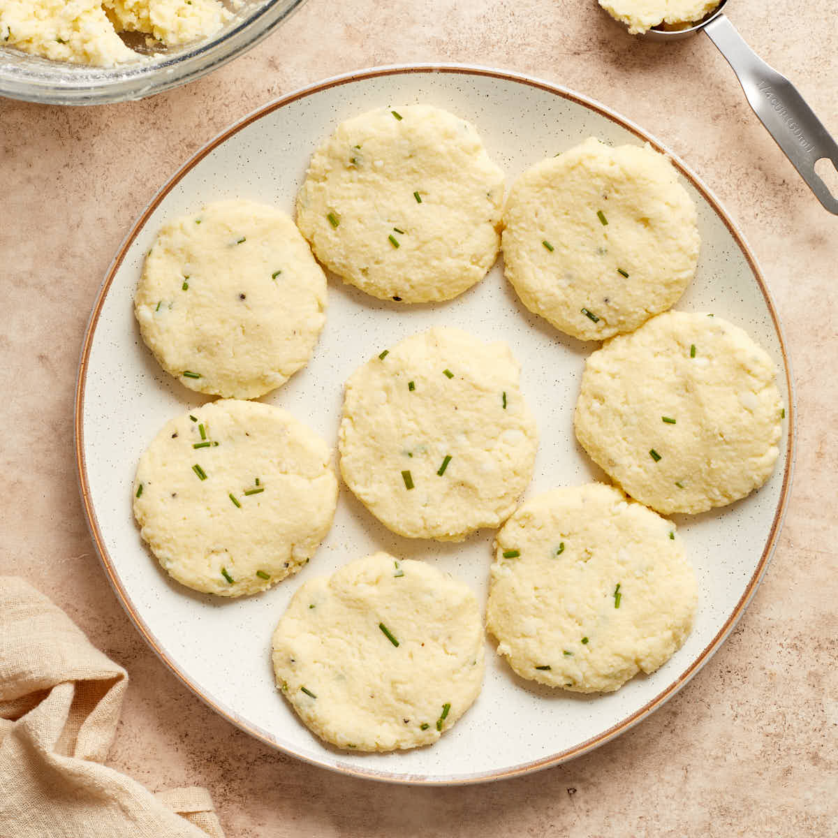 Mashed potatoes shaped into patties and arranged on a plate.