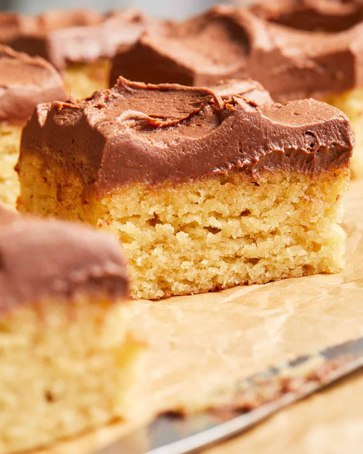 Up close view of a piece of banana cake with chocolate frosting on top.