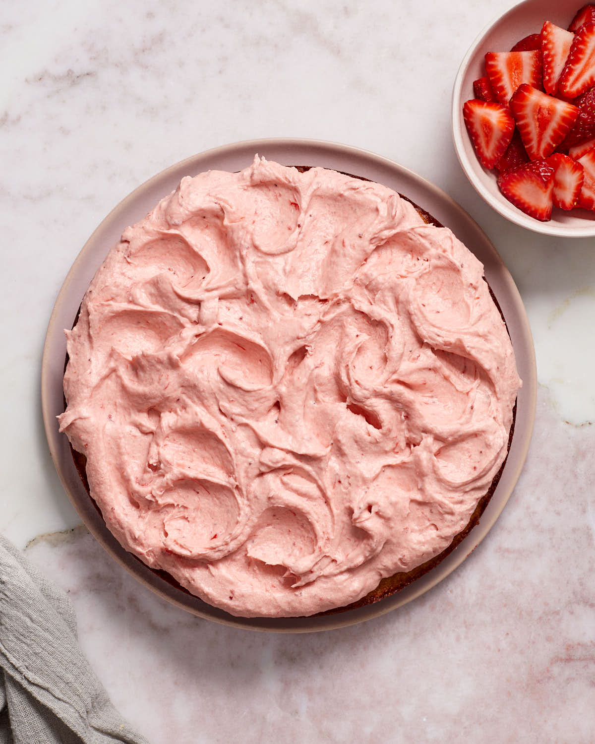 Overhead view of strawberry cake topped with strawberry frosting.