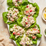 Tuna salad lettuce wraps arranged on a white oval platter.