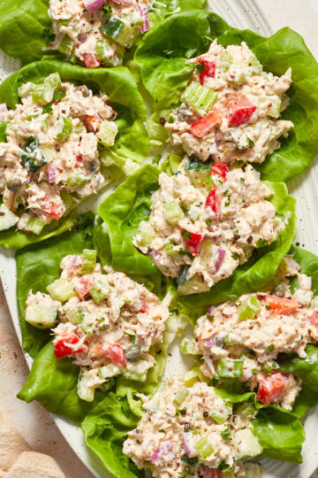 Tuna salad lettuce wraps arranged on a white oval platter.