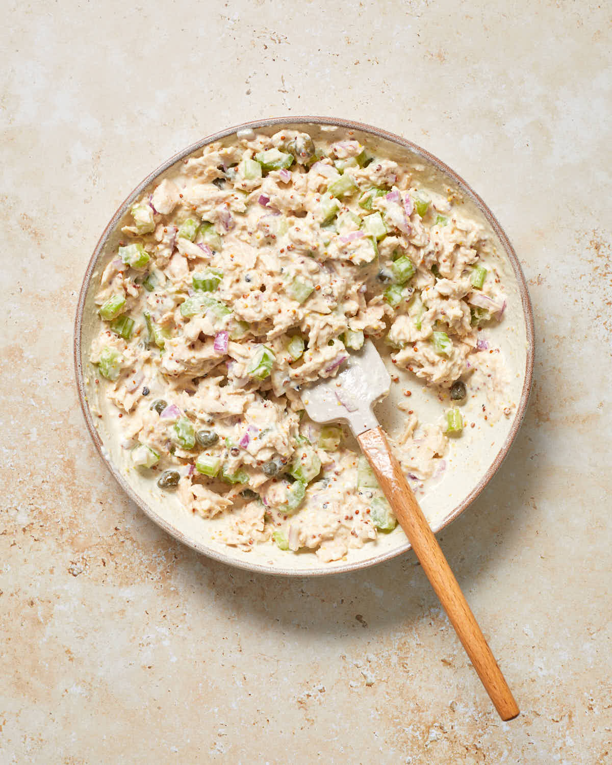 Tuna salad ingredients mixed together in a bowl.