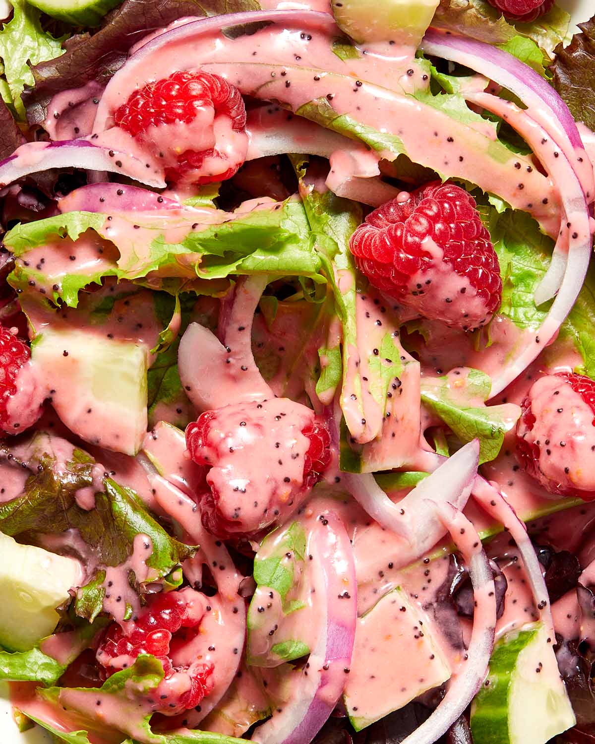Close up overhead view of raspberry dressing on top of a salad.