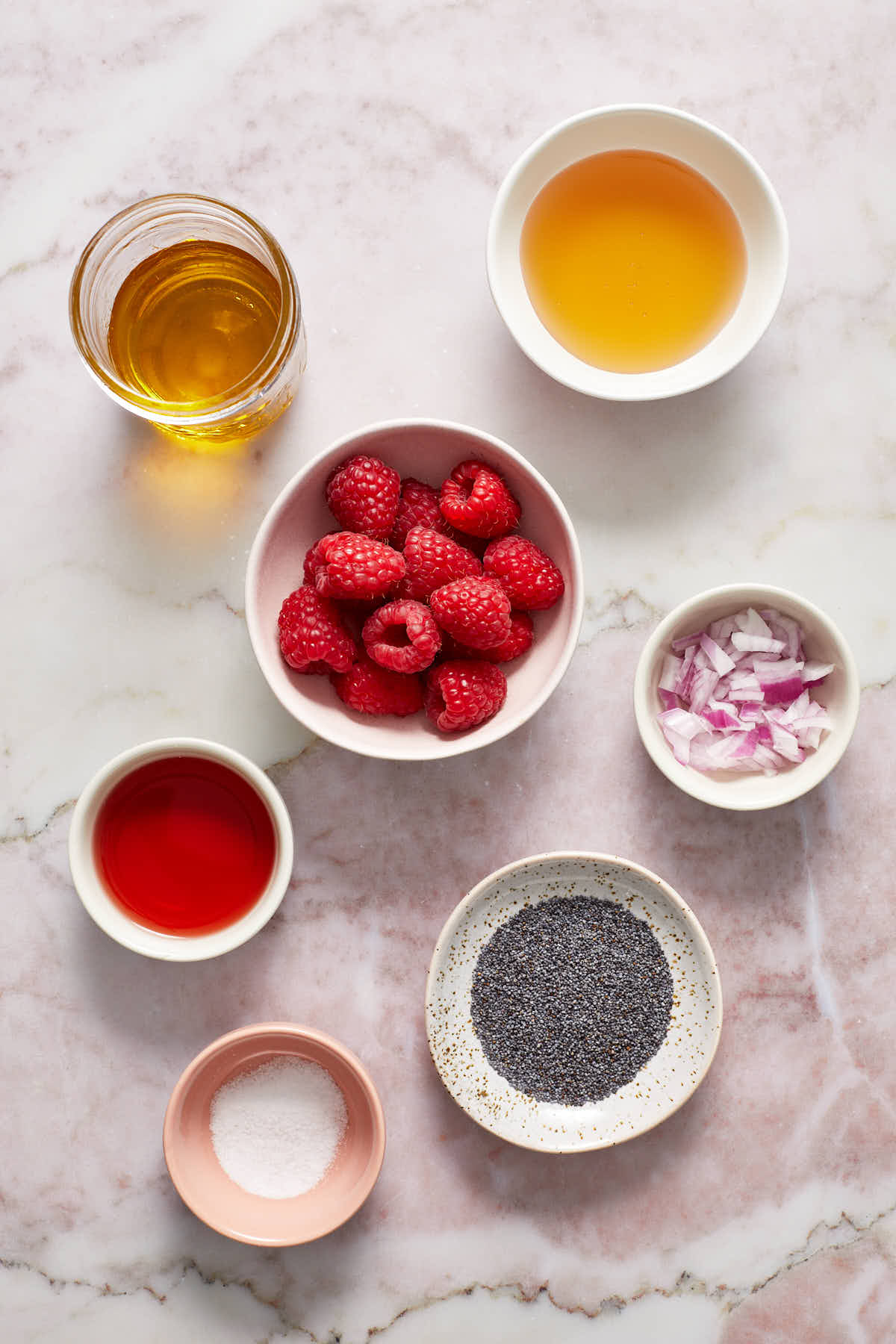 Ingredients to make raspberry poppy seed dressing arranged in individual dishes.
