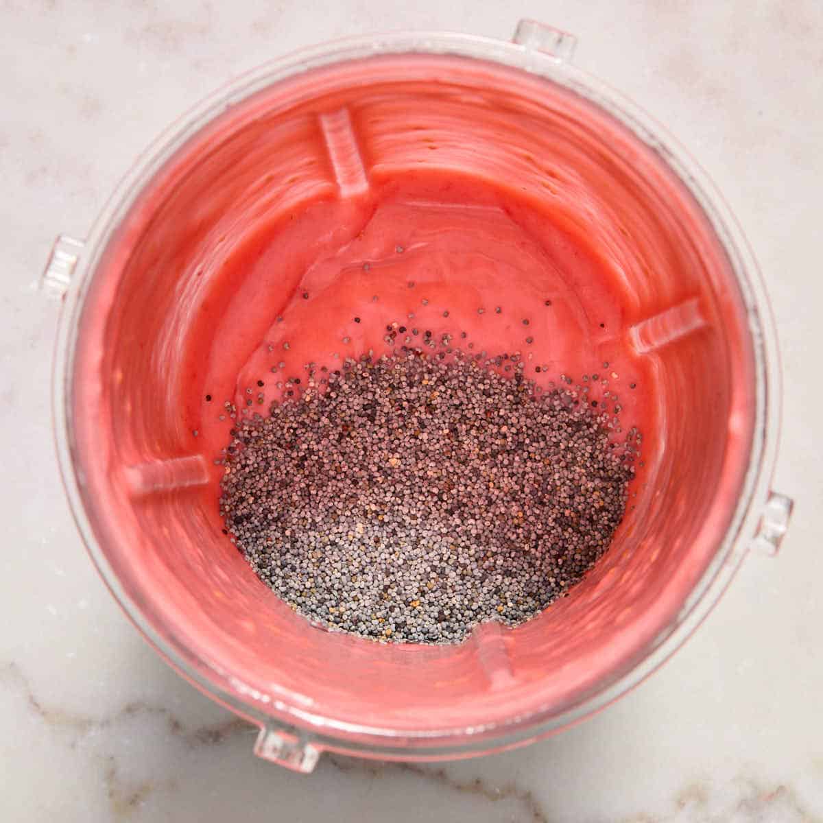 Poppy seeds added on top of the dressing in the cup.