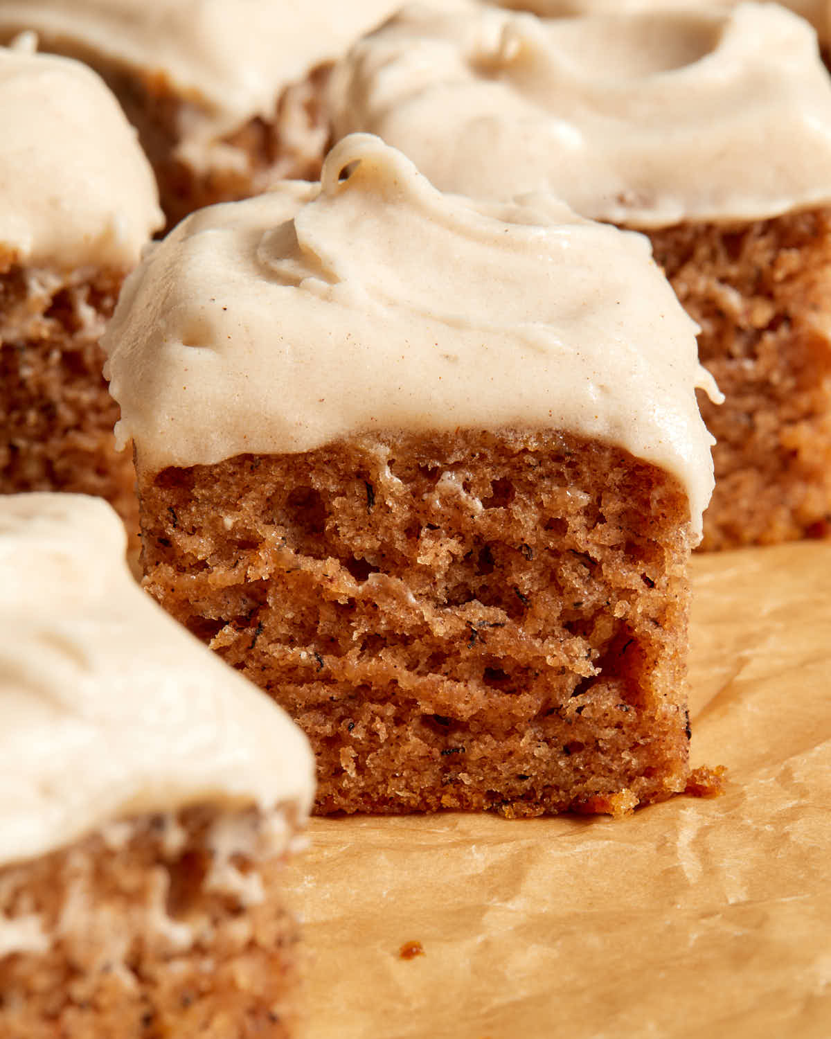 Side view of pieces of banana cake topped with frosting.