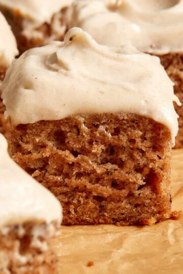 Close up view of a piece of banana cake topped with cinnamon cream cheese frosting.