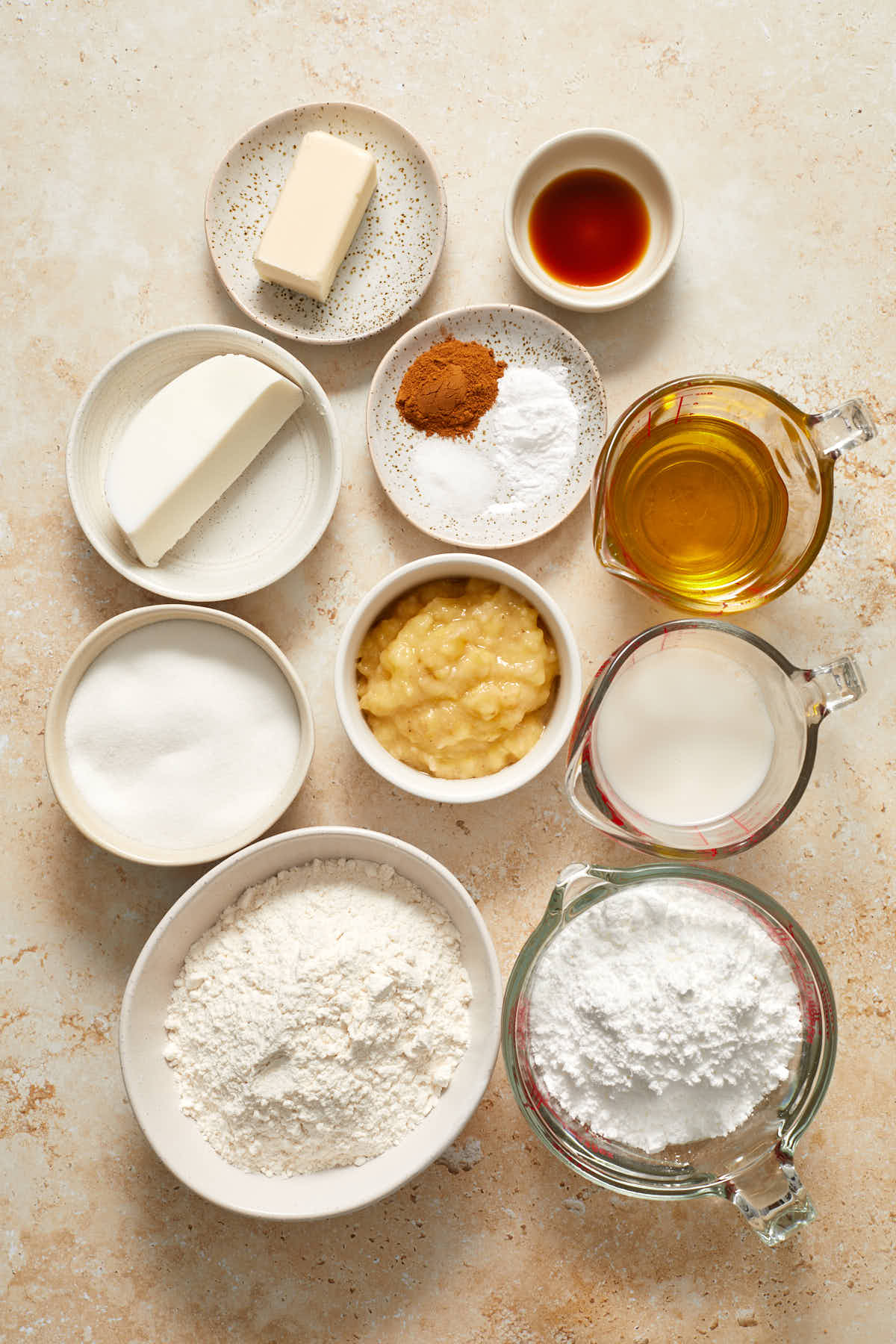 Ingredients to make banana cake and cream cheese frosting arranged individually.