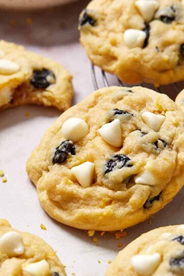 Close up view of a blueberry lemon cookie surrounded by other cookies.