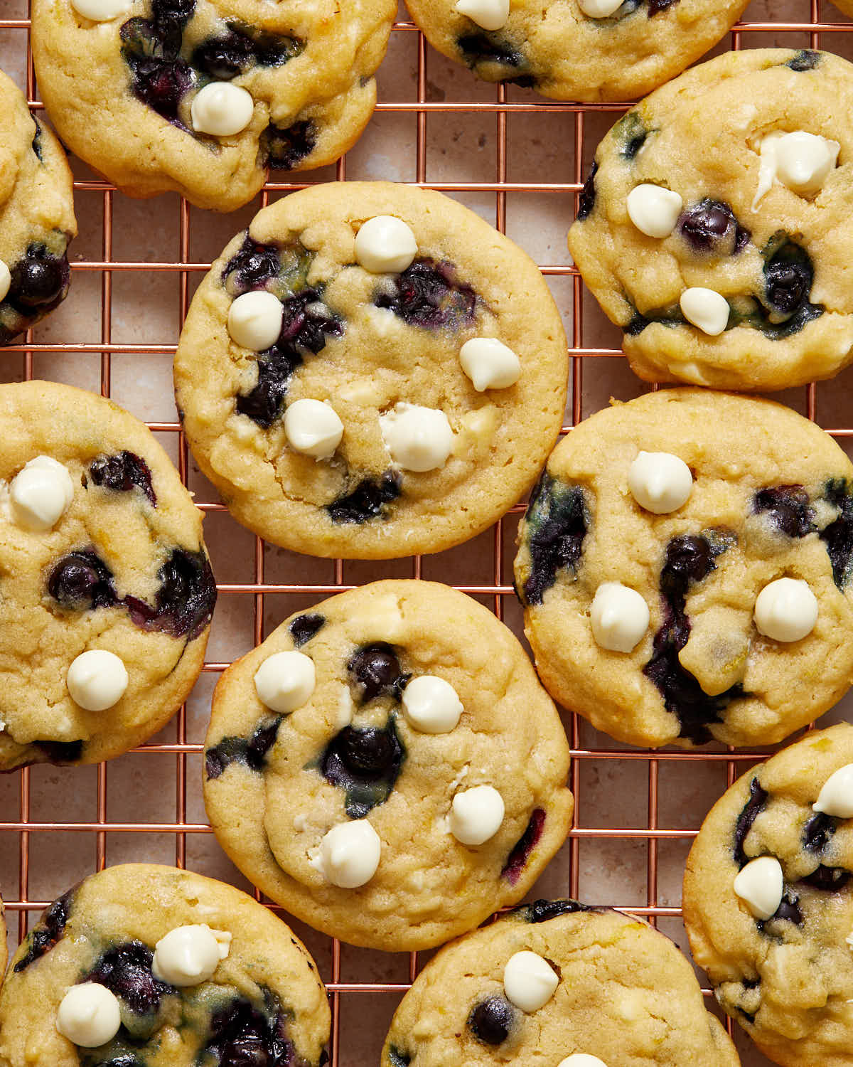 Cookies made with frozen blueberries on a cooling rack.
