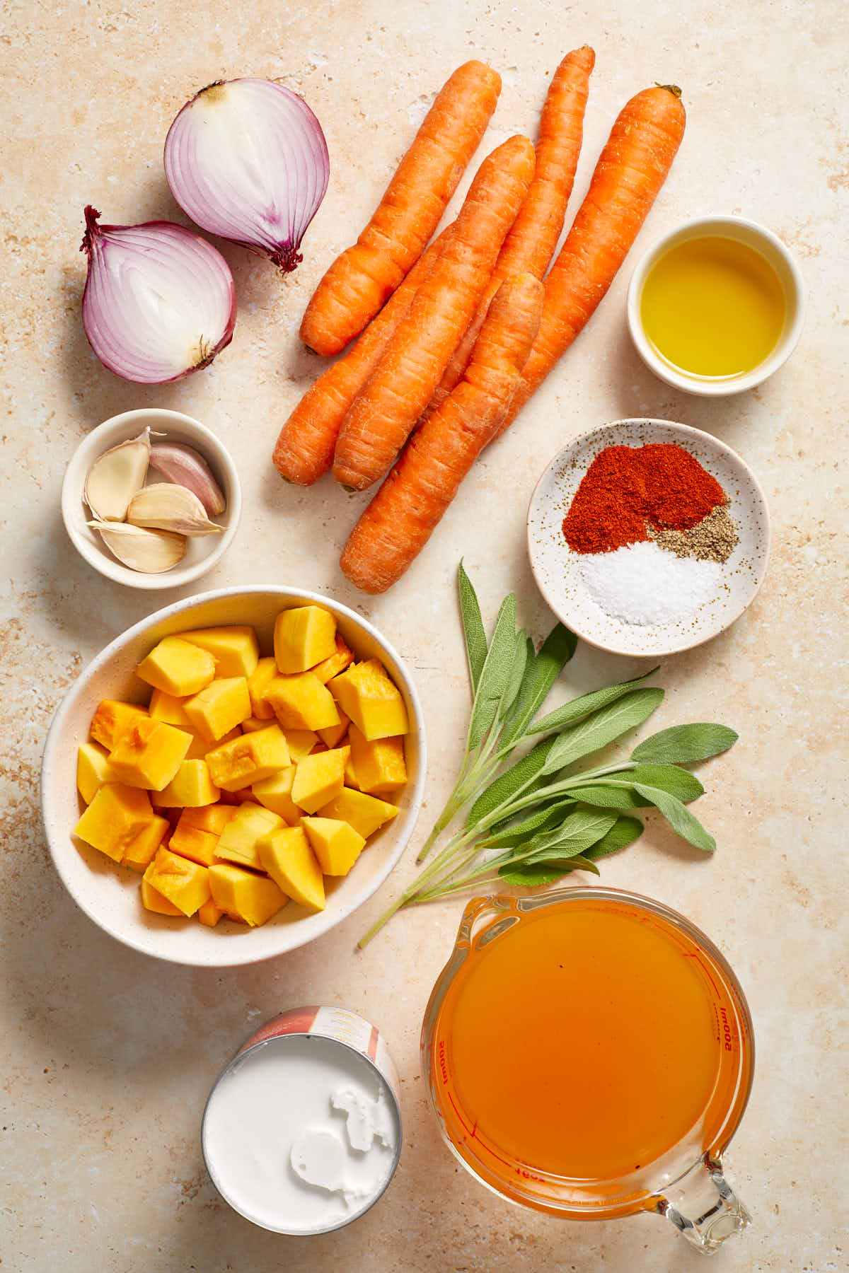 Ingredients to make carrot and butternut squash soup arranged individually.