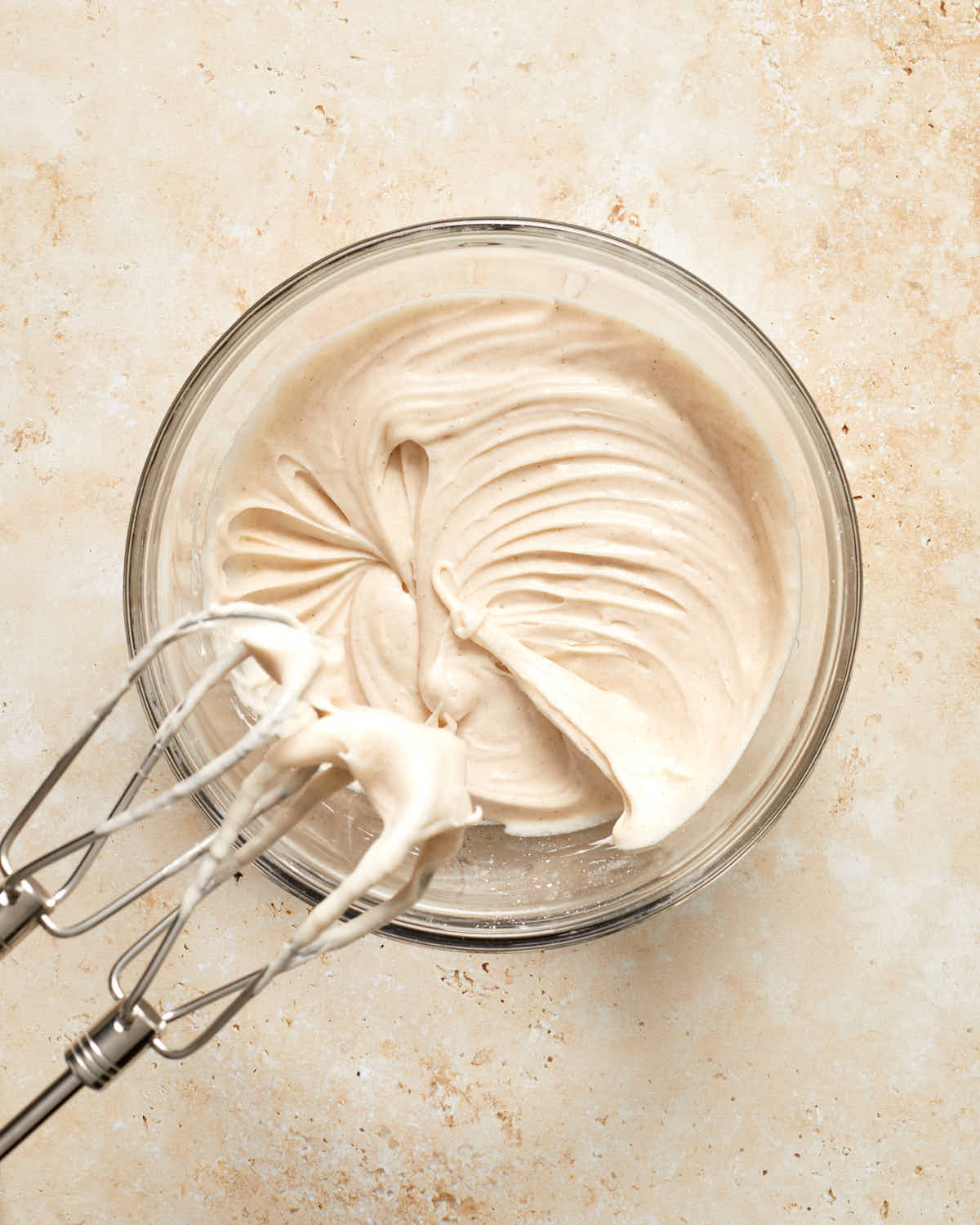 Cinnamon cream cheese frosting in a glass bowl.