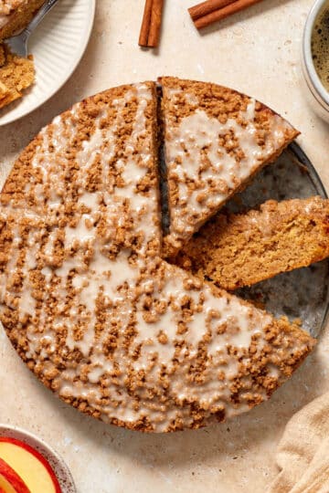 Almond flour apple cake cut into some slices with a piece on the side along with coffee and apple slices.