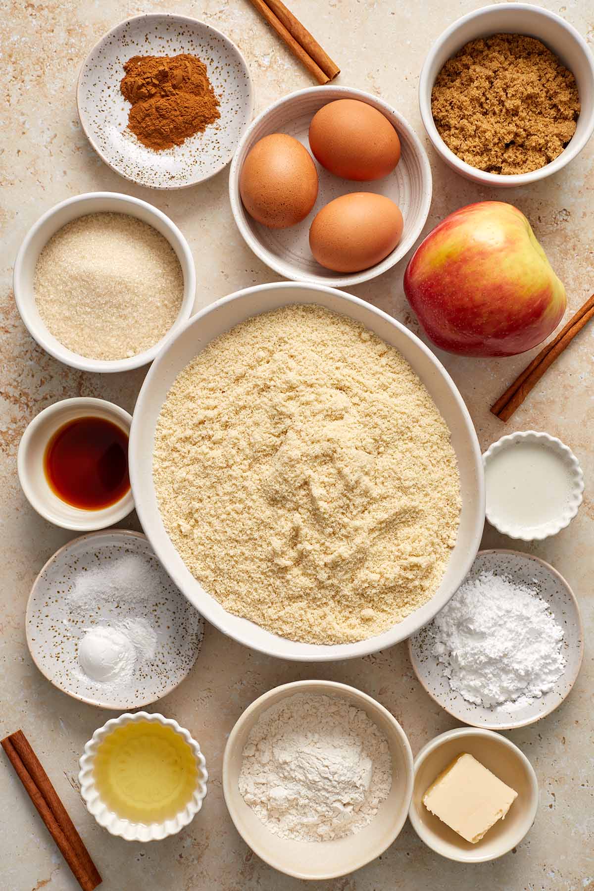 Ingredients to make almond flour apple cake arranged in individual bowls.