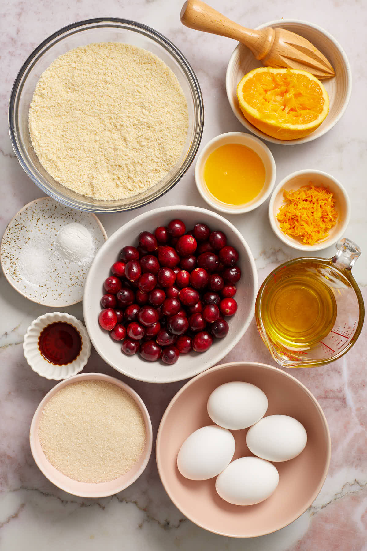 Ingredients to make almond flour cranberry orange bread arranged in individual bowls.