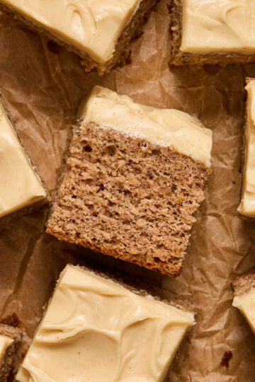 A piece of banana cake turned on its side with other pieces surrounding it.