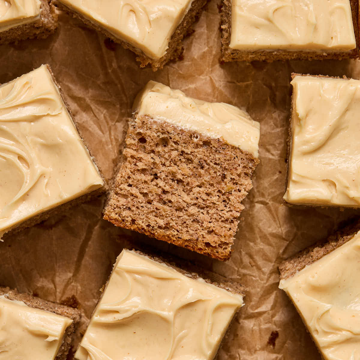 A piece of banana cake turned on its side with other pieces surrounding it.