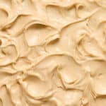 Close up view of peanut butter cream cheese frosting swirled on a cake.