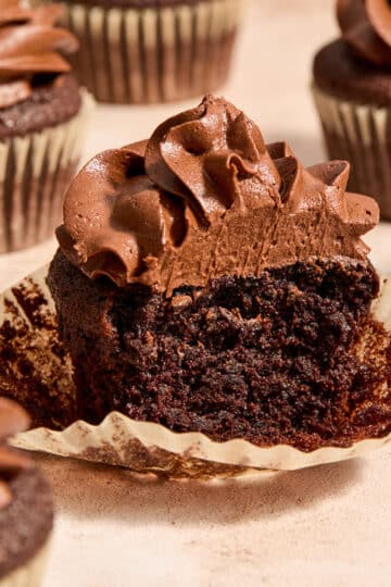 Side view of an almond flour chocolate cupcake with a bite taken out.