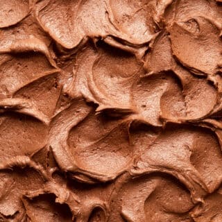 Close up view of swoops and swirls of chocolate peanut butter frosting on top of a cake.