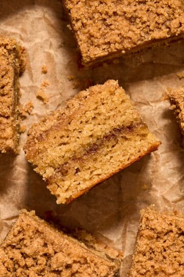 Pieces of almond flour coffee cake arranged on crumpled brown parchment paper.