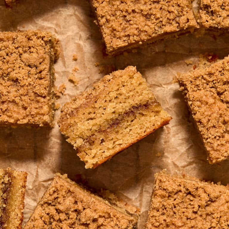 Pieces of almond flour coffee cake arranged on crumpled brown parchment paper.