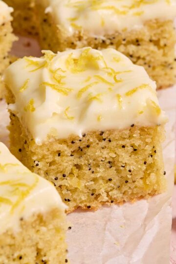 Pieces of almond flour lemon poppy seed cake arranged on parchment paper.