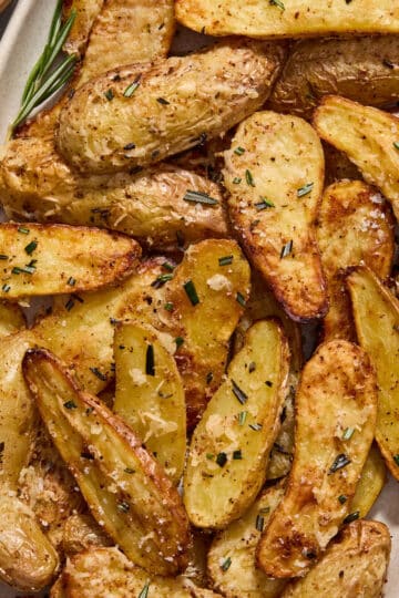 Air fryer fingerling potatoes served on a platter and topped with fresh rosemary.