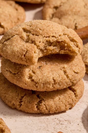 Stack of almond flour snickerdoodles with a bite taken out of the top one.