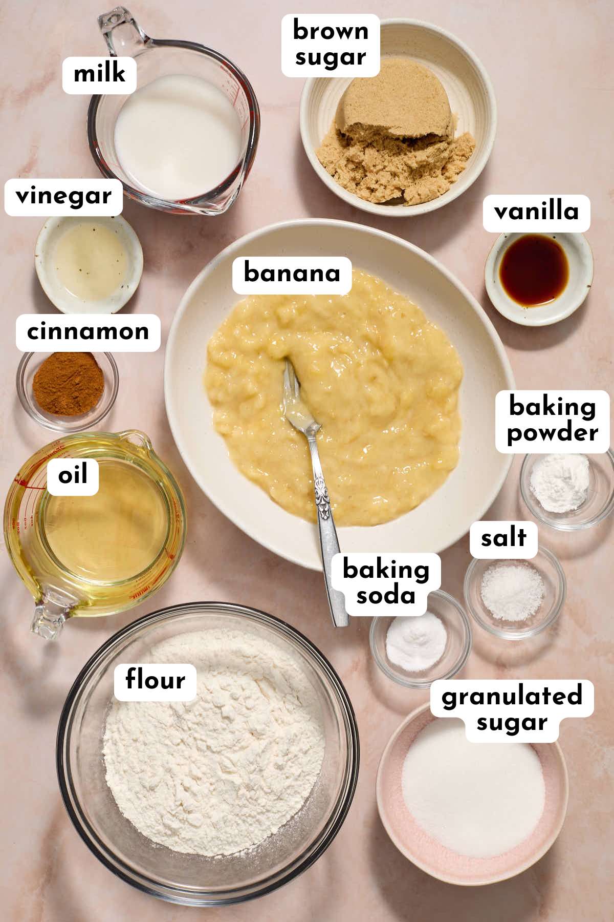 Ingredients to make an eggless banana cake arranged individually and labeled.