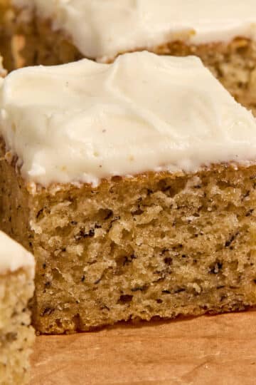 Side view of sour cream banana cake arranged on brown parchment paper.